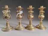 three gold candlesticks with a bird on top of them on a table