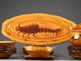 une assiette sur laquelle se trouve un insecte, à côté d'un bol et de tasses