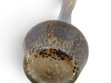 a brown and black vase on a white surface