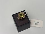 une bague sertie d'une pierre verte, dans un écrin noir
