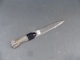 un couteau posé par terre à côté d'une corde