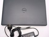 dell laptop computer with power cord and charger sitting on a white surface