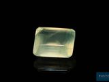 une pierre de quartz verte posée sur une surface noire