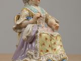 a figurine of a woman sitting on a table
