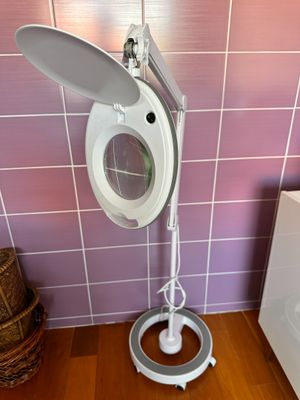 une lampe blanche posée sur un pied dans une salle de bains