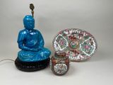 a blue buddha statue next to a bowl and a plate