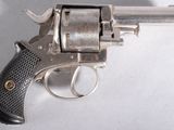 un pistolet posé sur une surface blanche