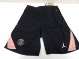 a pair of black shorts with pink detailing and a gold logo on the side