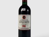 la bouteille de vin rouge est posée sur une surface blanche