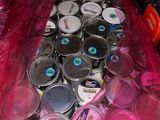 many cans of paint in a plastic bag on the floor