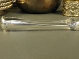 a silver spoon sitting on a table next to a silver bowl