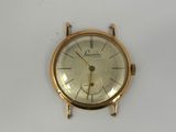 a gold watch on a white surface with a white background