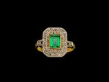 une bague sertie d'une émeraude et de diamants sur fond noir