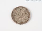 a silver coin on a white surface with a white background