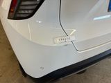 the rear end of a white car with a sticker on it ' s bumper