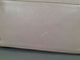 a close up of a white purse on a table