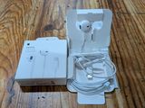 a box with earphones and a charger on a wooden floor