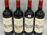 trois bouteilles de vin rouge sont alignées sur une table