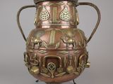 a large metal vase with many designs on it
