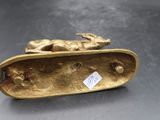 un gros plan sur une figurine en or représentant un chien sur un skateboard