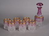 six verres et une carafe posés sur une table