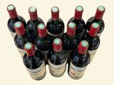 bottles of red wine are lined up in a row on a table