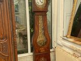 a grandfather clock in the corner of a room next to a radiator