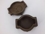 two brown plastic ashtrays sitting on top of a white table