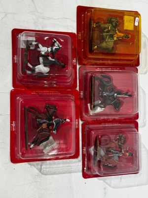 four plastic toy figures of a man riding a horse