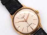 a close up of a watch on a white surface