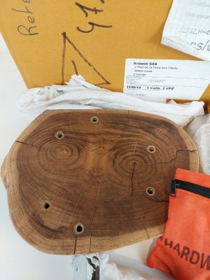 une boîte sur laquelle est posé un morceau de bois et un sac muni d'une étiquette
