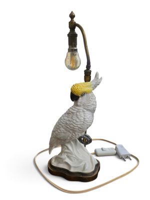 a white bird that is sitting on top of a lamp