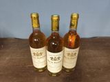 three bottles of wine sitting on top of a table next to each other