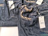 two pairs of blue jeans with tags on them sitting on a table