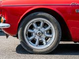 a close up of a red car parked in a parking lot