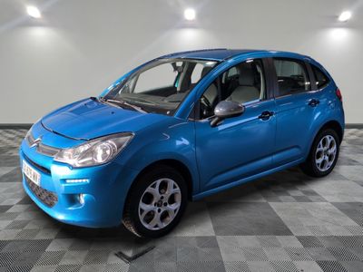 la petite voiture bleue est garée dans une pièce au sol à carreaux