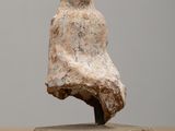 statue of a woman sitting on a block on a wooden table
