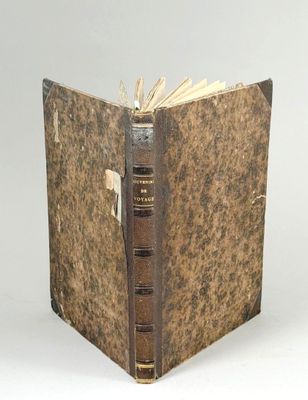 un vieux livre ouvert sur une surface blanche