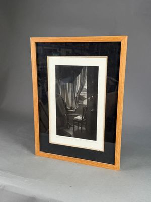 une vieille photo d'une chaise dans une pièce avec une fenêtre