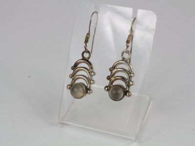 a pair of earrings on a clear display stand