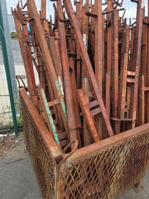 un panier rempli de barres de fer rouillées sur le trottoir