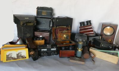 beaucoup de vieux appareils photo et d'autres objets posés sur une table