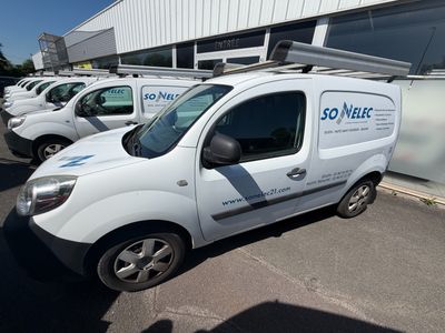plusieurs fourgonnettes blanches garées sur un parking à côté d'un immeuble