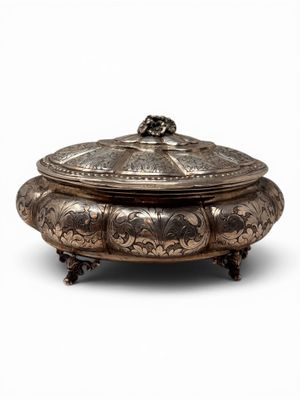 a silver plate with a lid and a handle on a stand