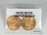 deux pièces d'or dans un sachet en plastique transparent portant un logo
