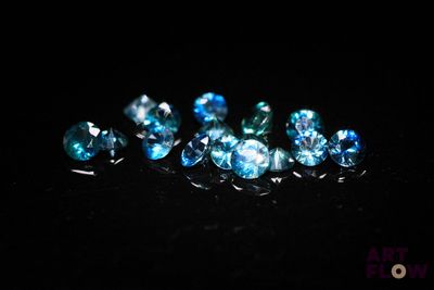 a close up of a bunch of blue diamonds on a black surface