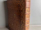 an old book sitting on top of a table next to a wall