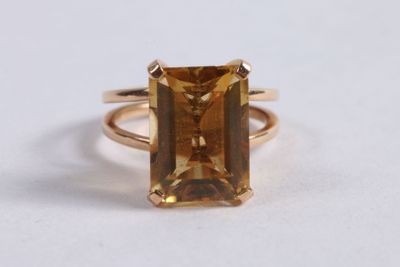 un gros plan sur une bague en or jaune sertie d'une émeraude