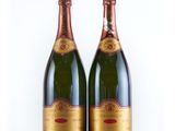 deux bouteilles de champagne posées l'une à côté de l'autre sur une surface blanche