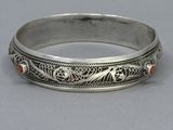a close up of a silver ring with red stones on it